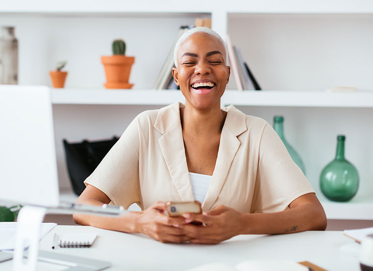 Happy young woman looking up from phone